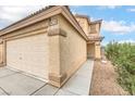 Exterior view of the two-car garage with a long driveway and desert-friendly landscaping at 9626 Grapeland Ave, Las Vegas, NV 89148