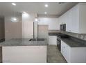 Modern kitchen features white cabinets, granite countertops, stainless steel appliances, and a central island at 10449 Forked Run St, Las Vegas, NV 89178
