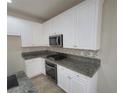 Well-equipped kitchen with white cabinets, granite countertops, stainless steel appliances, and tile backsplash at 10449 Forked Run St, Las Vegas, NV 89178