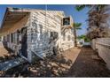 View of the side of a single-story home showcasing weathered wood siding and an external cooling unit at 1213 New Mexico St, Boulder City, NV 89005