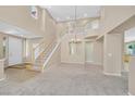 A grand foyer with high ceilings, a staircase, and a chandelier, creating a welcoming first impression at 1557 Sabatini Dr, Henderson, NV 89052