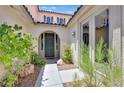 Inviting front entrance with a garden setting and a covered archway leading to the front door at 1557 Sabatini Dr, Henderson, NV 89052