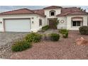 Inviting front yard with desert landscaping leads to a well-maintained home with a red tile roof and stucco exterior at 2524 Banora Point Dr, Las Vegas, NV 89134