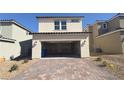 Two car garage with brick paved driveway and desert landscaping at 2713 Abrantes Pl, Henderson, NV 89044