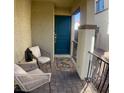 Inviting front porch with seating, a floral rug, black metal railings, and a bright blue front door at 302 Bay Village Pl, Henderson, NV 89011