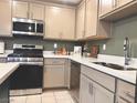 Updated kitchen with stainless steel appliances, neutral cabinets, and white countertops at 302 Bay Village Pl, Henderson, NV 89011