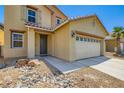 Two-story home with tan siding, desert landscaping, a two-car garage, and a tile roof at 3437 Visionary Bay Ave, North Las Vegas, NV 89081