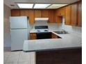 Bright kitchen featuring wood cabinetry, white appliances, and ample countertop space at 4300 N Lamont St # 232, Las Vegas, NV 89115
