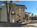Exterior view of condo with covered stairways leading to upper-level units and some parking at 4451 Rich Dr # D, Las Vegas, NV 89102