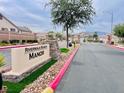 View of the community entrance sign with red accents and manicured landscape at 4717 Mohawk River Ave, North Las Vegas, NV 89031