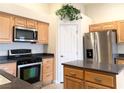 Bright kitchen featuring wooden cabinets, granite countertops, stainless steel appliances, and functional center island at 4717 Mohawk River Ave, North Las Vegas, NV 89031