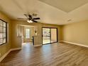 Bright living room with wood floors, ceiling fan, and sliding glass doors to a patio with a community view at 4805 Nara Vista Way # 203, Las Vegas, NV 89103