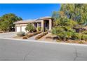 Single-story home displaying desert landscaping, a three-car garage, and a tile roof at 5193 N Miller Ln, Las Vegas, NV 89149