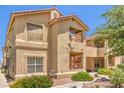 Exterior view of a two-story condo with a balcony and well-kept landscaping at 520 Arrowhead Trl # 522, Henderson, NV 89015