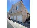 Neutral-toned townhome showing three-car garage and upper-level windows on a sunny day at 5969 High Steed St # 101, Henderson, NV 89011
