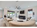 Bright living room featuring tile floors, a ceiling fan, a large sectional sofa and a wall-mounted TV at 6519 Summershade St, North Las Vegas, NV 89086