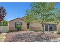 Inviting single story home showcasing desert landscaping, with an iron screen door at 6647 Montezuma Castle Ln, North Las Vegas, NV 89084