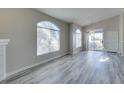 Bright living room with vaulted ceilings, arched windows, and gray wood-look flooring at 700 Carnegie St # 122, Henderson, NV 89052