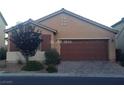 Single-story house featuring a two-car garage, neutral stucco exterior, complemented by a tile roof, and xeriscaped front yard at 7112 Whitford St, Las Vegas, NV 89166
