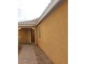 View of front door and xeriscaped yard of single-story stucco home at 7112 Whitford St, Las Vegas, NV 89166