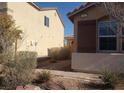 View of stucco home with tiled roof, xeriscaping, and adjacent neighbor's house at 7112 Whitford St, Las Vegas, NV 89166