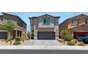 Two-story home featuring a paved driveway, gray stucco, and attached garage, and manicured landscape at 7432 Red Plumeria Ave, Las Vegas, NV 89113