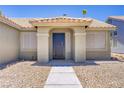 Inviting front entryway with a decorative security door, neutral stucco, and desert landscaping at 7713 White Grass Ave, Las Vegas, NV 89131
