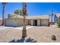 Single story home showcasing low-maintenance desert landscaping and palm trees against a blue sky at 7713 White Grass Ave, Las Vegas, NV 89131