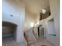Curved staircase featuring decorative iron railing, marble steps and tiled floors at 7728 Villa De La Paz Ave, Las Vegas, NV 89131