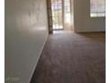 A well lit living room with neutral carpeting and a view of the backyard at 780 Vortex Ave, Henderson, NV 89002