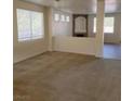 A well lit living room with neutral carpeting, white walls, and an archway to another room at 780 Vortex Ave, Henderson, NV 89002
