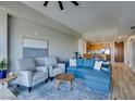 Comfortable living room with a blue sectional sofa, two chairs, and an adjacent dining area at 8255 Las Vegas S Blvd # 1414, Las Vegas, NV 89123