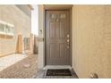 View of the home's front door with welcome mat, and low-maintenance landscaping at 8278 Palladium St, Las Vegas, NV 89113