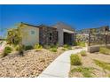 Contemporary home design with stone accents and low-maintenance desert landscaping at 901 Allister Fields Ln, Las Vegas, NV 89138