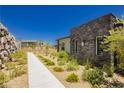 Modern home exterior showing desert landscaping and accent stone wall at 901 Allister Fields Ln, Las Vegas, NV 89138