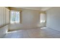 Bright living room featuring tile flooring, neutral walls, and natural light from the windows at 9017 Iron Hitch Ave, Las Vegas, NV 89143