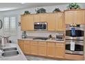 Well-lit kitchen featuring stainless appliances, including double ovens, and light wood cabinets at 11240 Romette Ct, Las Vegas, NV 89141