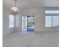 Bright living room featuring carpet flooring, multiple windows and sliding glass door at 2101 High Mesa Dr, Henderson, NV 89012