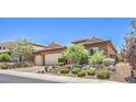Charming single-story home with a tile roof, stone accents, and a meticulously manicured front yard at 2509 Chateau Napoleon Dr, Henderson, NV 89044