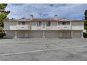 Exterior view of condo building with garages, balconies, and desert landscaping at 2633 S Durango Dr # 202, Las Vegas, NV 89117