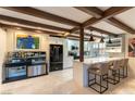 Bright kitchen with white cabinetry, marble countertops, stainless steel appliances, and bar seating under pendant lights at 2845 Queens Courtyard Dr, Las Vegas, NV 89109