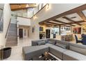 Open-concept living area with high ceilings, exposed beams, a sectional sofa, and seamless kitchen access at 2845 Queens Courtyard Dr, Las Vegas, NV 89109
