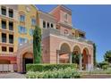 Elegant building exterior with an arched entryway, fountain, colorful facade, and manicured landscaping at 30 Strada Di Villaggio # 118, Henderson, NV 89011