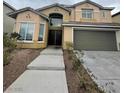 Inviting two-story home with a double-door entryway and attached two-car garage, set against a neatly landscaped front yard at 3237 Perching Bird Ln, North Las Vegas, NV 89084