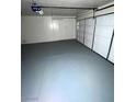 Clean, empty two-car garage with a gray epoxy floor and white walls, ready for customization and organization at 3237 Perching Bird Ln, North Las Vegas, NV 89084