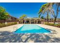 Community swimming pool surrounded by mature trees and a fenced enclosure for privacy at 3720 Royal Crest St # 6, Las Vegas, NV 89119