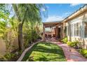 Relaxing backyard with covered patio, lush lawn, and mature landscaping at 4760 Verdet St, Las Vegas, NV 89147