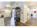 Stylish foyer with wood-look tile flooring, decorative shelving, and a view into multiple rooms at 5104 Drummond Rd, Las Vegas, NV 89130