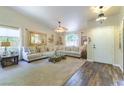 Bright living room with high ceilings, neutral furniture, and a view of the front yard through a large window at 5104 Drummond Rd, Las Vegas, NV 89130