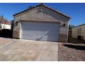 A house with a two car garage and a long concrete driveway situated in front, and an arid landscape at 733 Hitchen Post Dr, Henderson, NV 89011